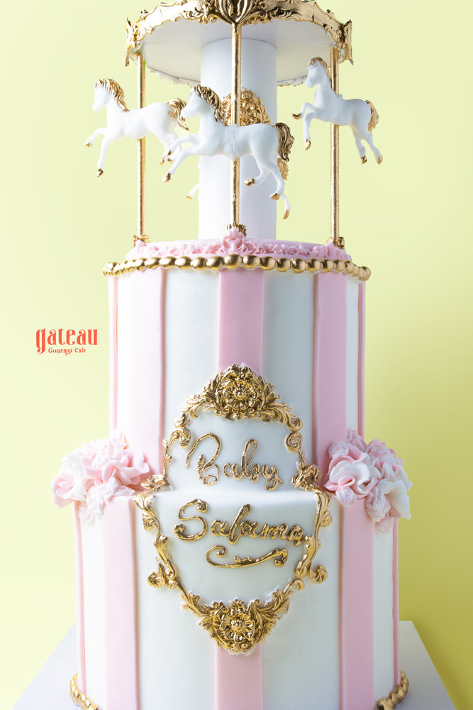 Custom carousel birthday cake with white horses and elegant gold details for special celebrations