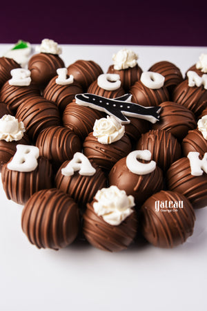 Gateau Gourmet Cafe custom chocolate truffle box with decorated chocolate truffles and white cream toppings