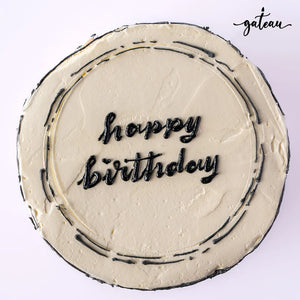 Custom colored cakes from Gateau Gourmet Cafe featuring a 'Happy Birthday' message on a cream frosting