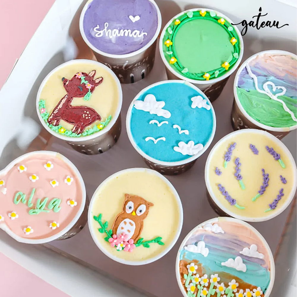 Nine custom decorated cups featuring colorful designs and personalized names from Gateau Gourmet Cafe