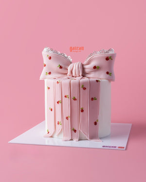 Elegant pink custom designed cakes by Gateau Gourmet Cafe shaped like a gift with floral details