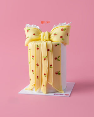 Custom designed cakes by Gateau Gourmet Cafe featuring a yellow bow decorated with small red roses