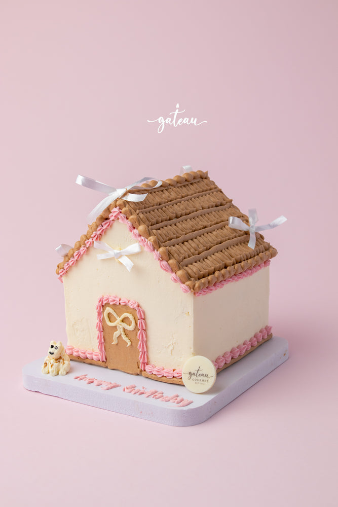 Custom house-shaped cake with brown roof and pink icing details from Gateau Gourmet Cafe