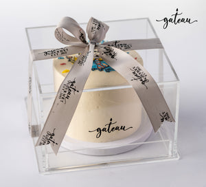 Custom minion birthday cake from Gateau Gourmet Cafe in clear gift box with branded ribbon