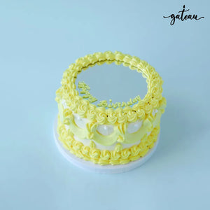 Yellow custom mirror cake from Gateau Gourmet Cafe with floral decorations and a reflective top for celebrations