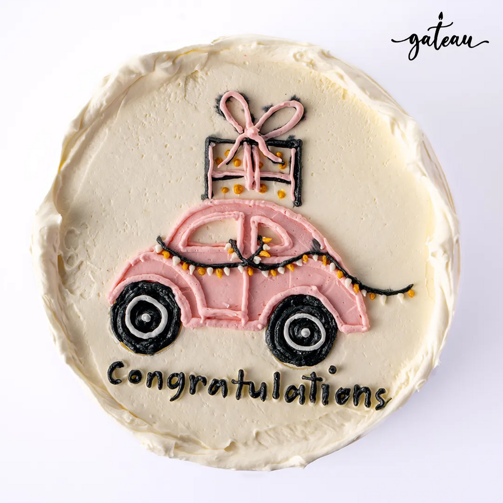Custom new car cake decorated with a pink car design and congratulations message for celebrations