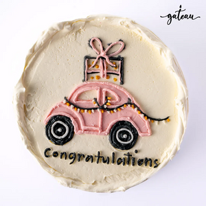 Custom new car cake decorated with a pink car design and congratulations message for celebrations