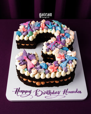 Gateau Gourmet Cafe custom number cakes decorated with colorful seashell and starfish frosting on a chocolate cake base