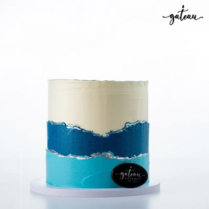 Gateau Gourmet Cafe custom ombre birthday cake with blue and white layered frosting on a white cake board