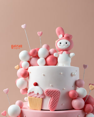 Custom pink birthday cake designed by Gateau Gourmet Cafe with cute decorations and a playful character