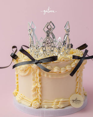 Custom royal cake design by Gateau Gourmet Cafe with creamy frosting and decorative silver crown