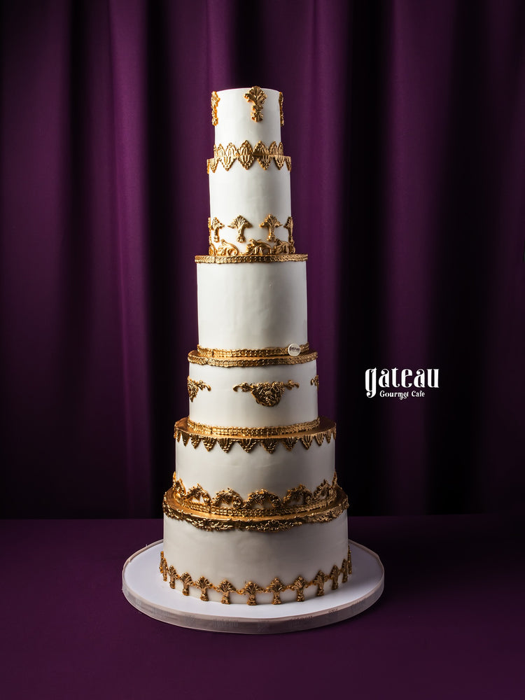 Gateau Gourmet Cafe custom royal cake tall white with gold decorative accents on multiple tiers