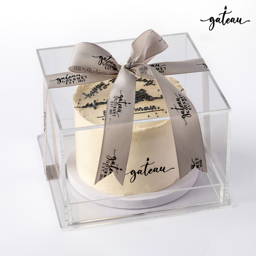 Gateau Gourmet Cafe custom sports cake with white frosting in clear gift box tied with branded ribbon
