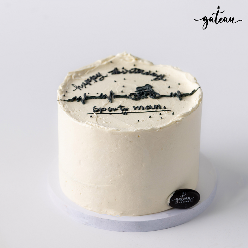 Gateau Gourmet Cafe custom sports cake with white frosting and black sports-themed decorations