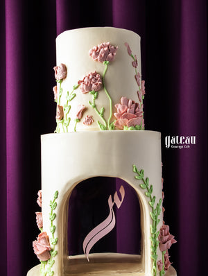 Elegant two-tier cake with pink floral decorations and custom wedding cake design by Gateau Gourmet Cafe
