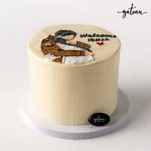 Gateau Gourmet Cafe custom welcome back cake with cream frosting and hand-decorated figure on top