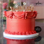 Customized crown birthday cake with elegant red frosting and decorative gold crown on top