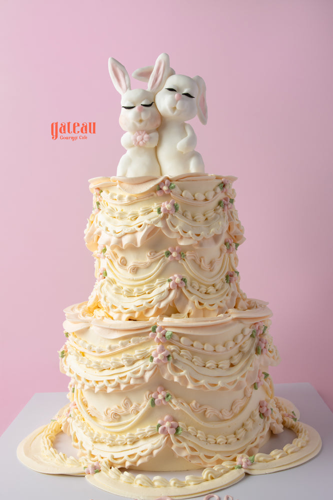 Cute bunny birthday cake with elegant layers and charming bunny figurines on top