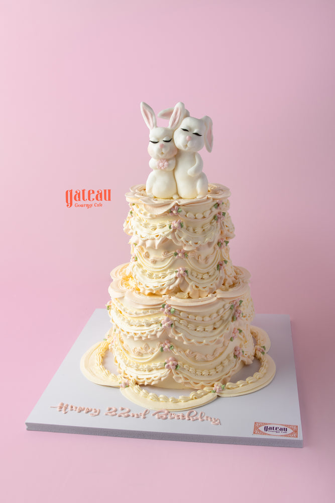 Cute bunny birthday cake with intricate icing, featuring two fondant bunnies on top, perfect for celebrations