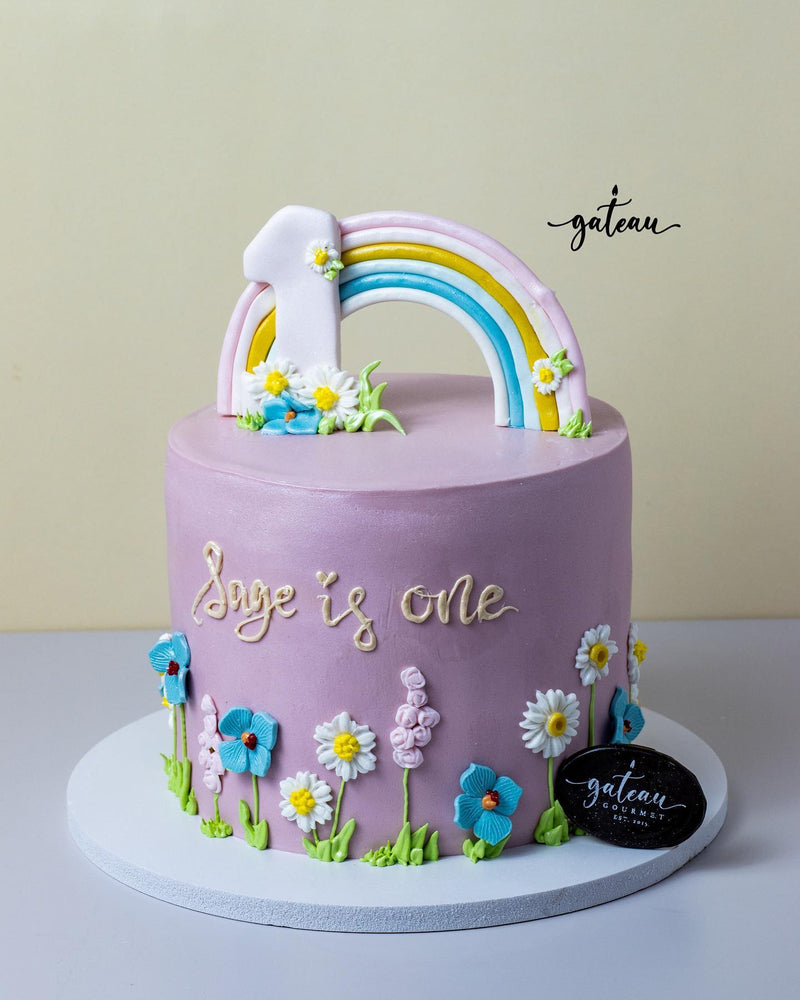 Cute Cinnamoroll Cake with a colorful rainbow and floral decorations for a first birthday celebration