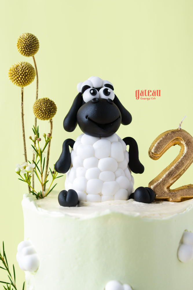 Cute sheep cake for kids with black and white decoration and golden number two candle