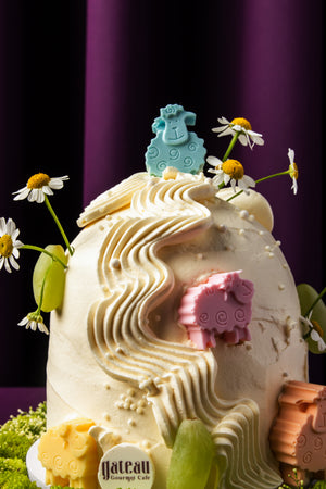 Eid Al Adha cake ideas featuring Gateau Gourmet Cafe cream cake with colorful sheep decorations and floral accents