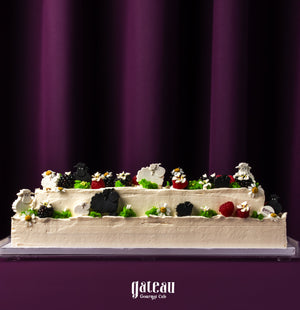 Gateau Gourmet Cafe two-tier cake decorated with sheep and berries perfect for Eid celebration desserts