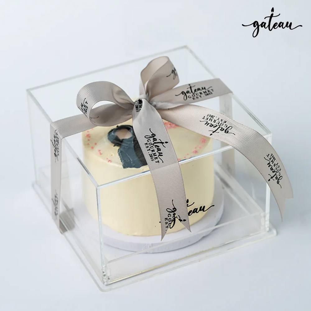 Gateau Gourmet Cafe cake in clear gift box with gray ribbon featuring Emirati woman design cakes