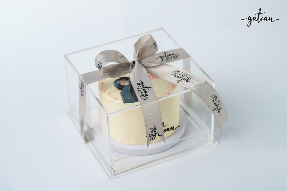 Gateau Gourmet Cafe cake with Emirati woman design cakes wrapped in a clear box with a branded ribbon