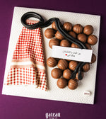 Father's Day chocolate truffles shaped like a stethoscope with a red patterned cloth on a white textured plate