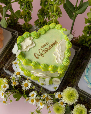 Gateau Gourmet Cafe floral cake arrangements with green and white frosting and butterfly decorations