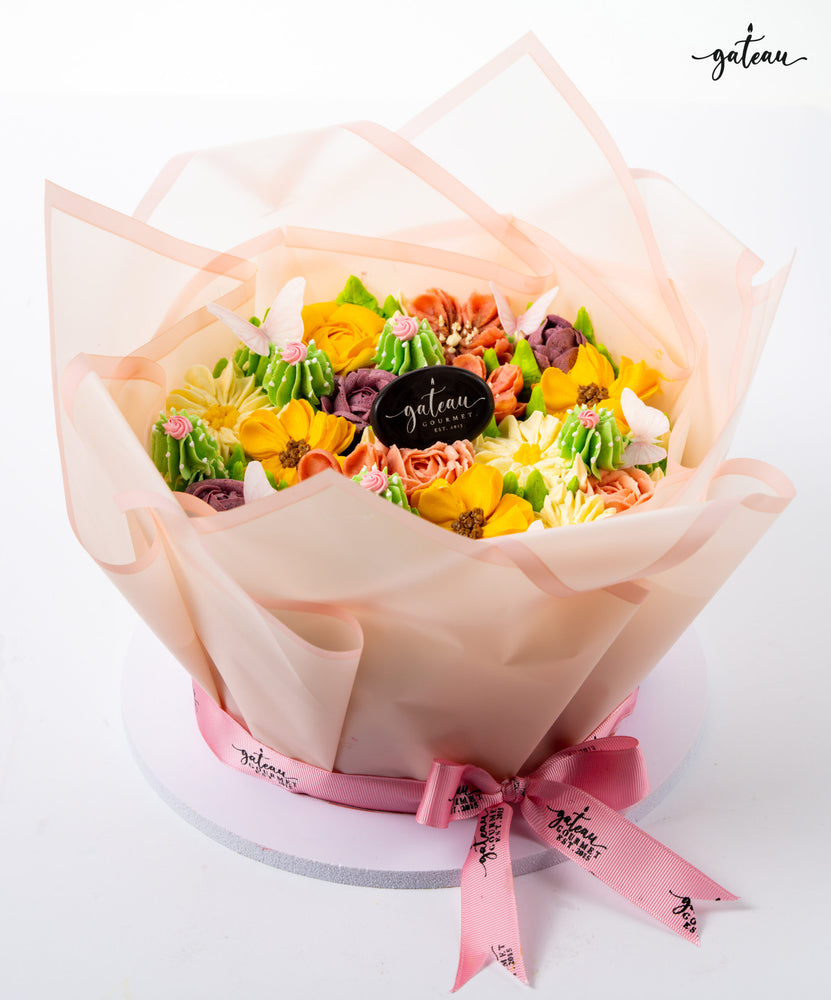 Floral cake decoration bundle from Gateau Gourmet Cafe featuring colorful buttercream flowers wrapped in translucent pink paper