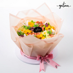 Floral cake decoration bundle with colorful buttercream flowers wrapped in translucent paper and pink ribbon
