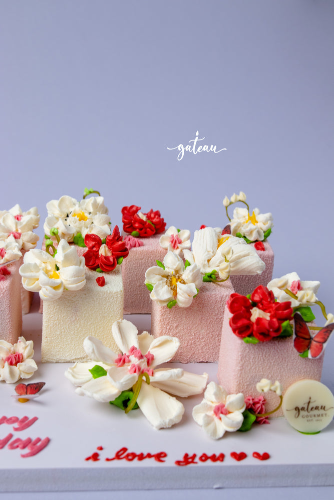 Floral decorated cake cubes in white and pink with red and white edible flowers by Gateau Gourmet Cafe