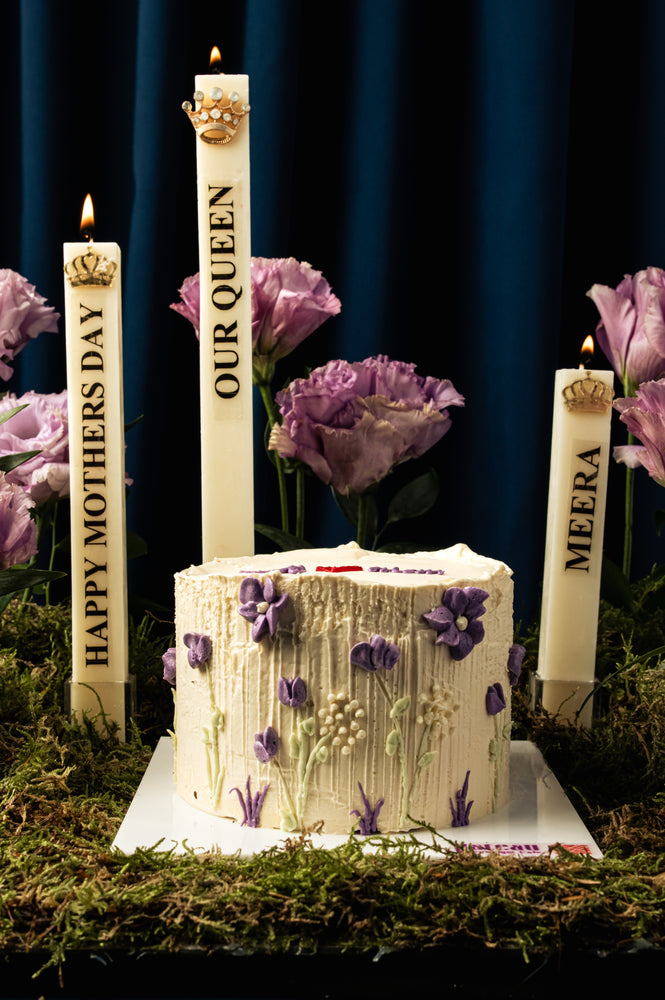 Floral Mother's Day cake with purple flowers and white frosting by Gateau Gourmet Cafe