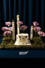 Floral Mother's Day cake decorated with purple flowers and candles on mossy base by Gateau Gourmet Cafe