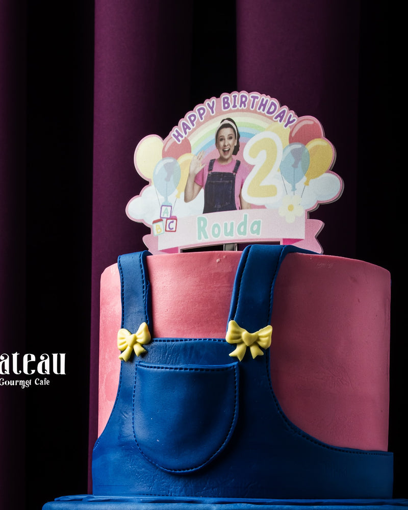 Fondant rainbow cake decorated with colorful balloons and a birthday topper for a 2nd birthday celebration