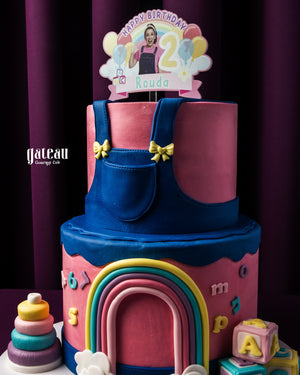 Colorful fondant rainbow cake with two-tier design and birthday decorations from Gateau Gourmet Cafe