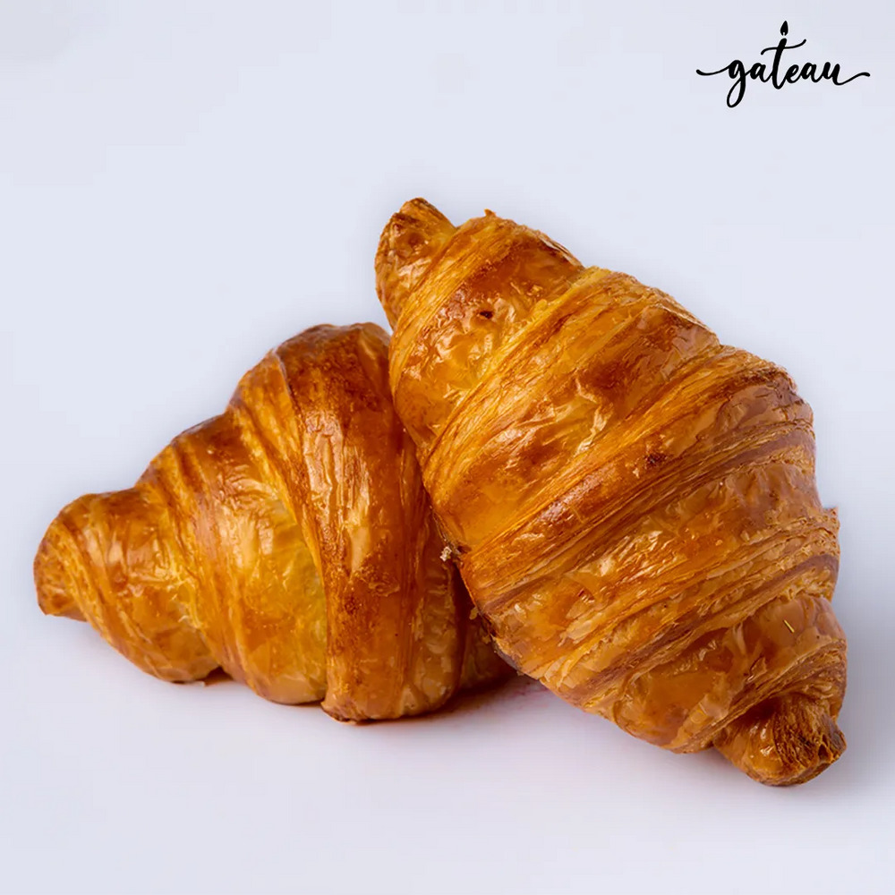 Two golden brown flaky croissants representing fresh baked croissants delivery from Gateau Gourmet Cafe