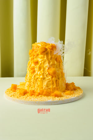 Fresh mango layered cake from Gateau Gourmet Cafe topped with mango chunks on white plate