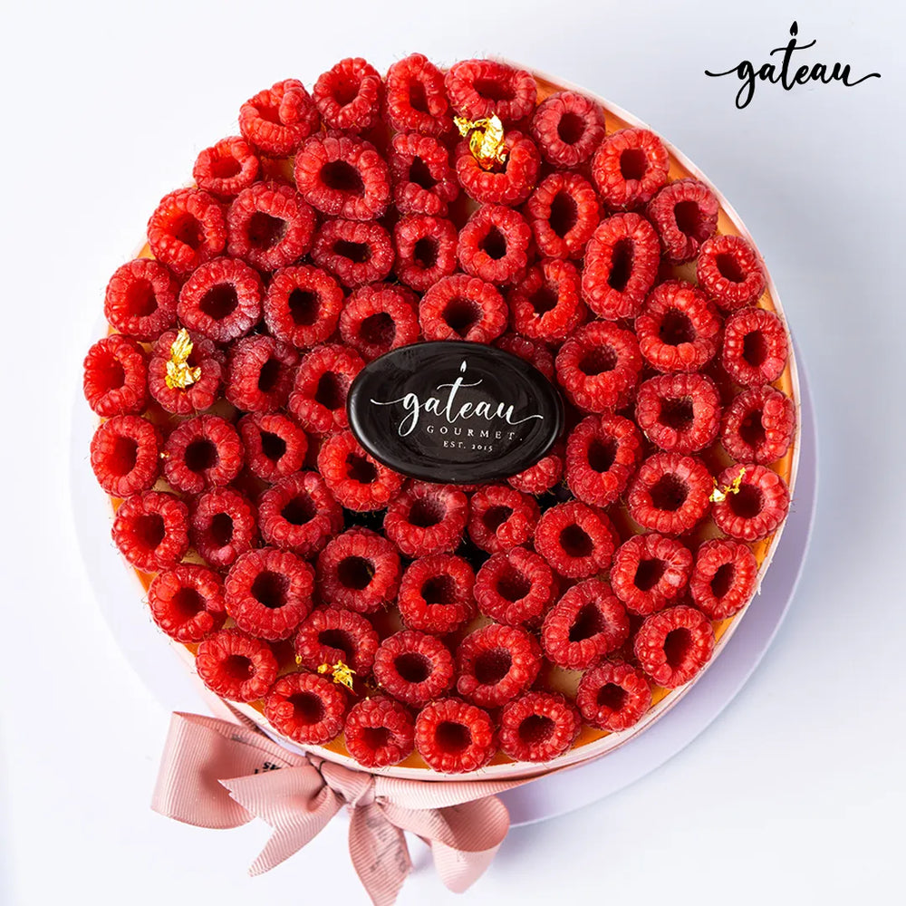 Gateau Gourmet Cafe fresh raspberry cheesecake delivery topped with numerous fresh raspberries and gold accents