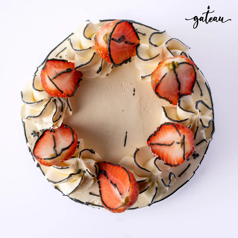 Delicious fresh strawberry cake topped with sliced strawberries and creamy frosting from Gateau Gourmet Cafe
