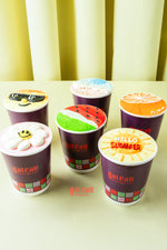 Fruit decorated cupcakes for parties from Gateau Gourmet Cafe in purple cups with colorful summer-themed designs