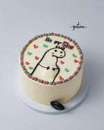 Gender reveal cake ideas from Gateau Gourmet Cafe featuring a white frosted cake with dinosaur and pink and blue decorations
