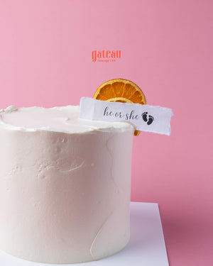 Elegant Gender Reveal Cake with a fresh orange slice and a charming message flag