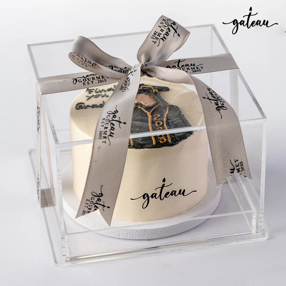 Gild graduation celebration cake from Gateau Gourmet Cafe in a clear gift box with decorative ribbon