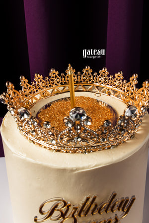 Gateau Gourmet Cafe gourmet birthday cake with white frosting and golden crown decoration