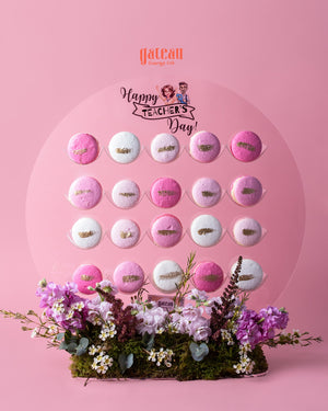 Gourmet macaroons with stand featuring pink and white macaroons arranged on clear circular stand with floral base for Teacher's Day