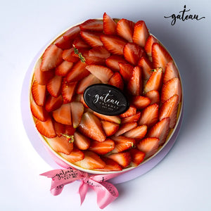 Gourmet strawberry cheesecake topped with fresh sliced strawberries and gold leaf accents from Gateau Gourmet Cafe