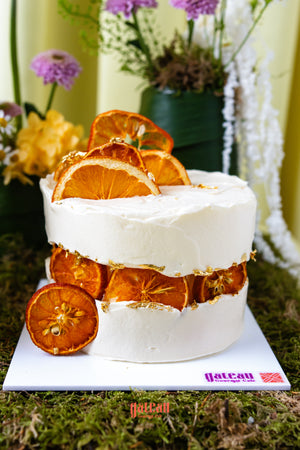 Gourmet summer birthday cake by Gateau Gourmet Cafe decorated with dried orange slices and white frosting